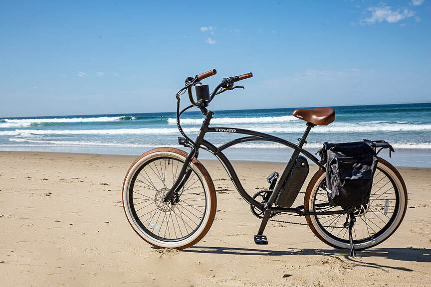 Urlaubszeit Ein stylishes Fahrrad steht am Strand, an den Wellen schlagen