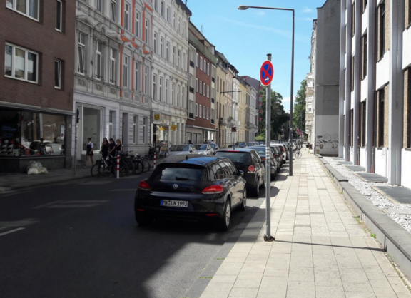 Der Status Quo der Lochnerstraße. Beidseitig sind Kfz geparkt, wodurch nur wenig freie Fahrbahnbreite bleibt.