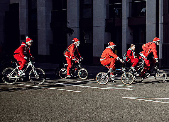 Eine Gruppe von Personen in Weihnachtsmännerkostümen auf Fahrrädern