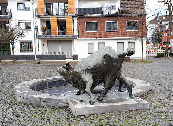 Brunnenanlage Junge schiebt Kuh in Aachen-Eilendorf von Wolfgang Binding aus dem Jahr 1988