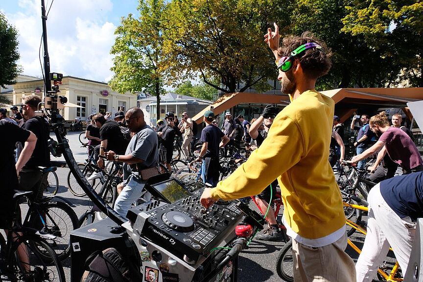 Newsletter 2025-03 Ein Mann mit Kopfhörern bedient ein Musikpult, das an einem Fahrrad angebracht ist