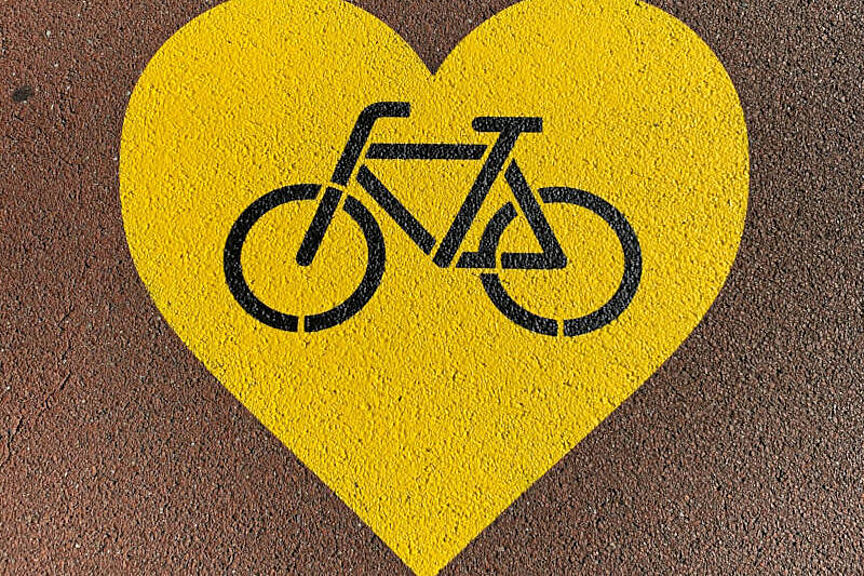 Fahrradliebe Ein symbolisiertes Fahrrad in einem Herz auf Asphalt gesprüht