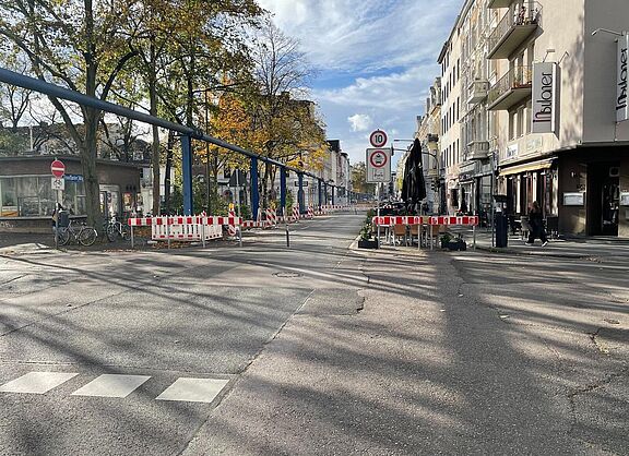 Die Bismarckstraße auf Höhe des Modalfilters am Neumarkt. Es sind zwei Poller und Warnbaken aufgestellt