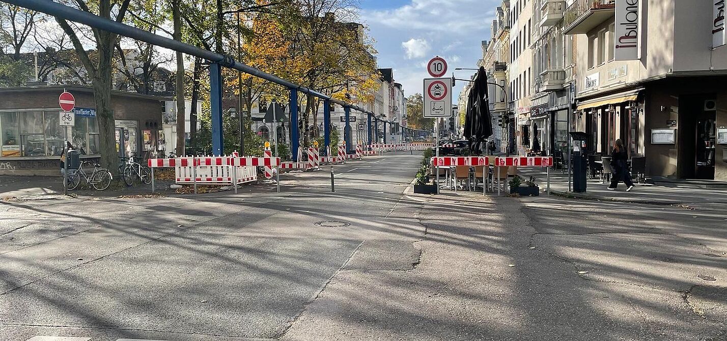 Die Bismarckstraße auf Höhe des Modalfilters am Neumarkt. Es sind zwei Poller und Warnbaken aufgestellt