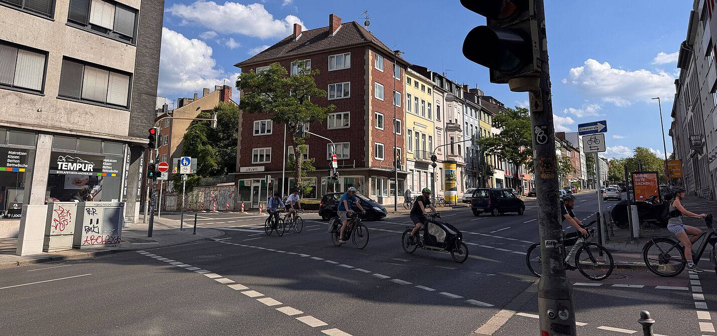 Das Foto zeigt die Querung der Radvorrangroute Brand/Eilendorf über die Wilhelmstraße und einige Radfahrende