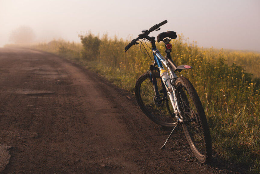 Fahrrad auf nebelverhangenem Feldweg Auf einem Feldweg abgestelltes Fahrrad, im Hintergrund Felder im Nebel