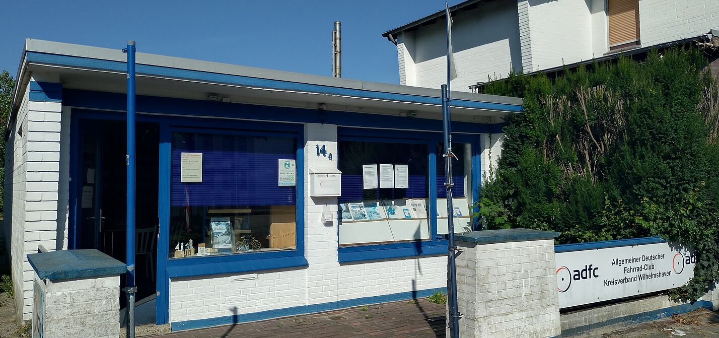 Ein weißer, gemauerter Bungalow mit blauen Tür- und Fensterrahmen.