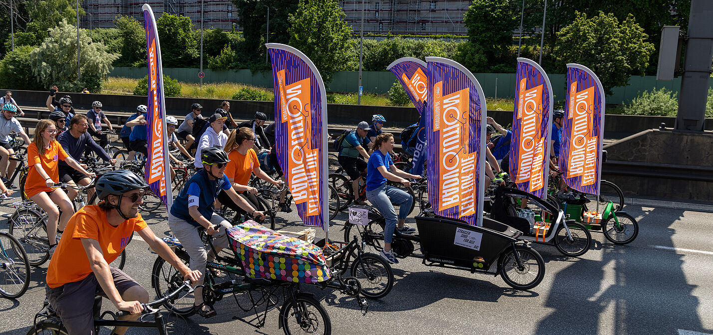 Radfahrende mit Beachflags bei der ADFC-Sternfahrt Berlin