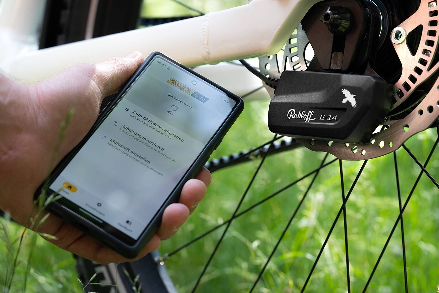 Eine Hand hält ein Smartphone mit der Rohloff App vor der Rohloff Schaltbox. 